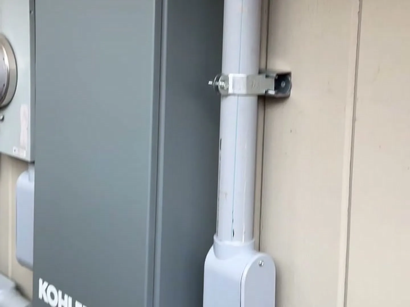 Automatic transfer switch and conduit run on a house wall from a standby generator installation in Houston