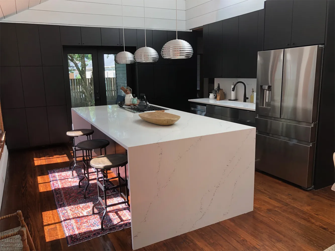 Home remodeling in Houston, TX: quartz waterfall island kitchen built by VCS Construction in a historic bungalow
