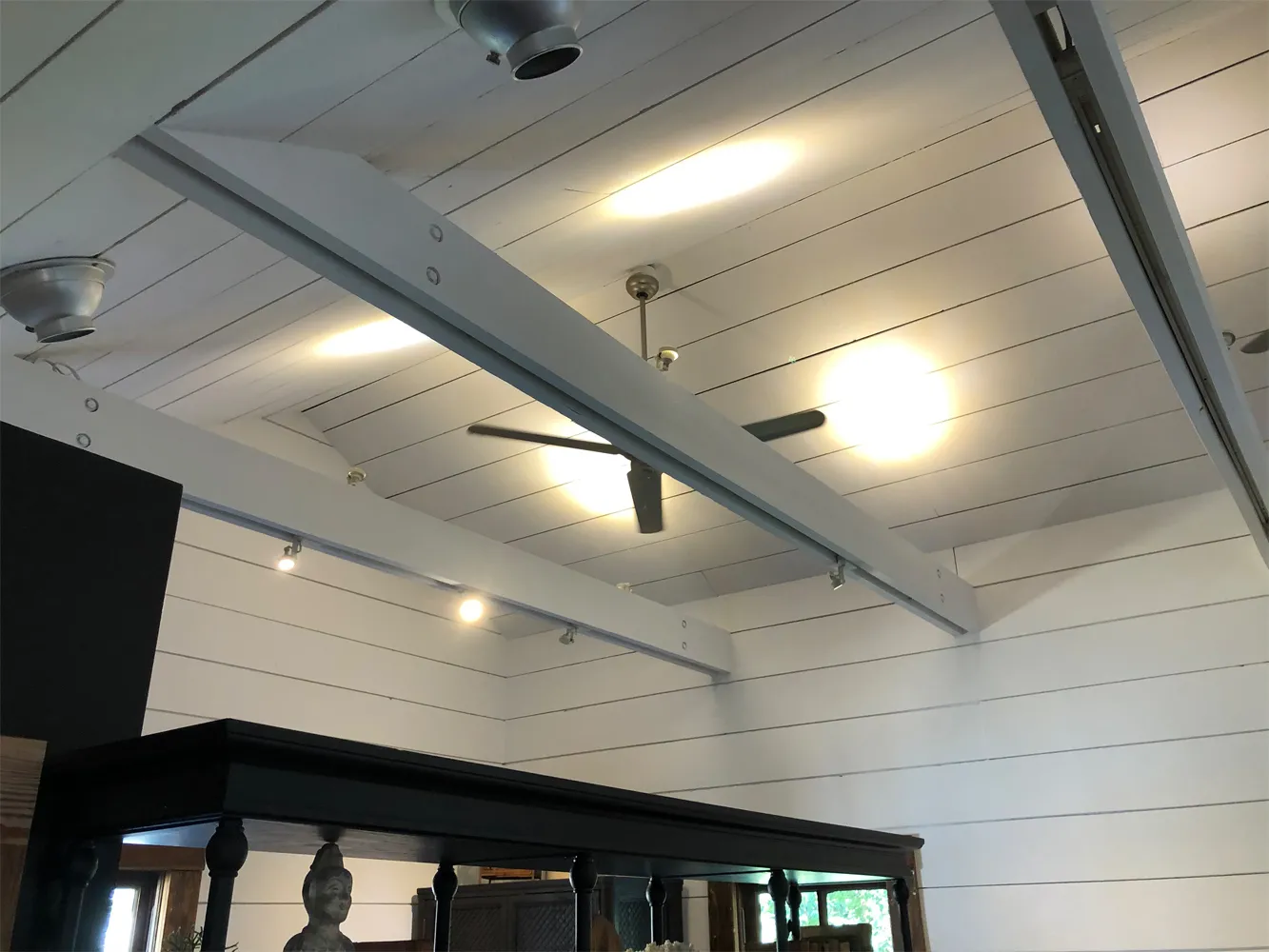 Ceiling fan and recessed lights installed on a vaulted shiplap ceiling in a remodeled Houston home