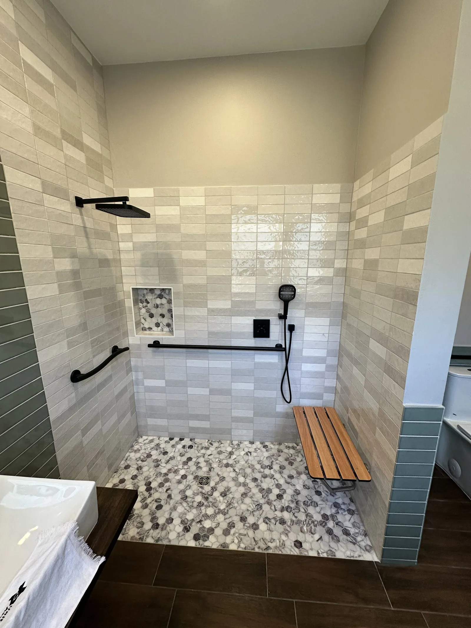 Walk-in shower with teak bench and grab bars